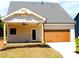 Stylish home featuring a wooden garage door, covered back porch, and manicured yard at 133 Old Alabama Se Rd, Emerson, GA 30137