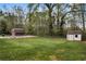 A grassy backyard features a pool, a red barn, and a shed surrounded by mature trees at 3046 Wendgate Dr, Marietta, GA 30062