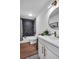 Modern bathroom featuring hexagon tiled shower, wood floors, and a gold-trimmed round mirror at 3046 Wendgate Dr, Marietta, GA 30062