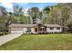 A beautiful ranch-style house featuring a well-manicured lawn, stone accents, and a garage at 3046 Wendgate Dr, Marietta, GA 30062