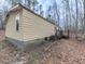 Side view of tan siding home with steps leading to a deck in wooded location at 1010 Martin Ln, Canton, GA 30114