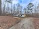 Exterior view of the house and lot surrounded by mature trees at 1010 Martin Ln, Canton, GA 30114