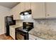 Close-up of black appliances, white cabinets and granite countertops in a kitchen at 1797 Old Dogwood, Jonesboro, GA 30238