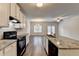 Stylish kitchen featuring granite countertops, stone backsplash, black appliances, and white cabinets at 1797 Old Dogwood, Jonesboro, GA 30238