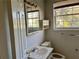 Bathroom featuring a sink, mirror, toilet, storage cabinet, and a window with natural light at 1920 Anastasia Ln, Atlanta, GA 30341