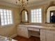 Bright bathroom featuring dual sinks, vanity with storage, stylish mirrors, and a window at 1920 Anastasia Ln, Atlanta, GA 30341