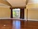 Sunny living room with hardwood floors and a large window with decorative curtains at 1920 Anastasia Ln, Atlanta, GA 30341