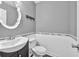 Modern half bathroom showcasing a white vanity, patterned mirror and gray wainscoting at 233 Tara Commons Walk, Loganville, GA 30052