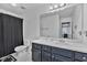 Well-lit bathroom featuring a sleek vanity, a large mirror, and a shower with a black curtain at 233 Tara Commons Walk, Loganville, GA 30052