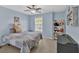 Bright bedroom features a ceiling fan, plush carpet, and natural light from the window at 233 Tara Commons Walk, Loganville, GA 30052