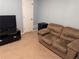 Living room with a comfortable brown couch, TV stand, and TV, offering a cozy space for relaxation at 233 Tara Commons Walk, Loganville, GA 30052