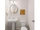 This powder room features a pedestal sink, round mirror, decorative artwork and neutral paint at 1342 Magnolia Way Bnd # 287, Jonesboro, GA 30238