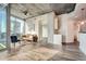 Modern living room with hardwood floors, exposed concrete ceiling, and expansive windows showcasing the city skyline at 3324 Peachtree Ne Rd # 2118, Atlanta, GA 30326