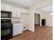 Bright kitchen featuring white cabinets, black appliances, hardwood floors, and opening to dining area at 345 Wimberly Way, Powder Springs, GA 30127