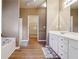 Well-lit bathroom featuring double vanity, a soaking tub, and a walk-in closet at 4985 Skyland Pkwy, Cumming, GA 30028