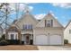 Charming two-story home featuring a stone facade, neutral siding, well-manicured landscaping, and a two-car garage at 4985 Skyland Pkwy, Cumming, GA 30028