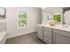Bathroom features a double vanity with gray cabinets and views of the outdoors at 9446 Cedar Grove Ct # 334, Jonesboro, GA 30238