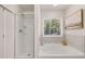 Bright bathroom features a shower, soaking tub, and a large window at 9446 Cedar Grove Ct # 334, Jonesboro, GA 30238