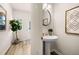 A stylish powder room with a pedestal sink, wood floors, and modern decor at 9448 Cedar Grove Ct # 333, Jonesboro, GA 30238