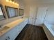 A bathroom with dual sinks and a bathtub featuring wood-look flooring at 3689 Deer Springs Trl, Ellenwood, GA 30294