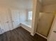 A bathroom with a bathtub and shower featuring wood-look flooring at 3689 Deer Springs Trl, Ellenwood, GA 30294