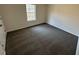Well-lit bedroom with neutral walls and carpet, and a window providing natural light at 3689 Deer Springs Trl, Ellenwood, GA 30294