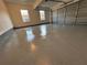 Spacious garage with an epoxy floor and a roll-up door, illuminated by natural light from windows at 3689 Deer Springs Trl, Ellenwood, GA 30294