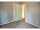 Bedroom with neutral walls, carpeted floors, and white trim, including a closet and doorway at 6929 Hickory Log Rd, Austell, GA 30168