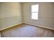 This carpeted bedroom features neutral paint and trim, with a bright window that provides natural lighting at 6929 Hickory Log Rd, Austell, GA 30168