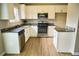 Well-lit kitchen with stainless steel appliances, granite countertops, and wood-look floors at 6929 Hickory Log Rd, Austell, GA 30168