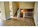 Open-concept living space with wood floors, stairs to the upper level, and a stone fireplace at 6929 Hickory Log Rd, Austell, GA 30168