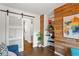 Inviting living area featuring wood accent wall, built-in shelves, and sliding barn door at 3351 Creatwood Se Trl, Smyrna, GA 30080