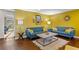 Bright living room with blue sofas, yellow accents, hardwood floors, and an open layout at 3351 Creatwood Se Trl, Smyrna, GA 30080