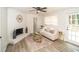 Cozy living room with fireplace, ceiling fan, wood flooring, and plenty of natural light from the windows and door at 4324 Rue Saint Michel, Stone Mountain, GA 30083