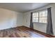 Cozy bedroom featuring a window, new wood-look flooring, fresh paint, and a doorway to an adjacent room at 5990 Mallory Rd, South Fulton, GA 30349