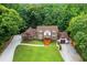 Charming two-story Tudor home with a lush green lawn and mature trees surrounding the property at 3996 Spalding Ln, Atlanta, GA 30350