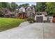 Elegant brick home featuring a covered front porch and a detached garage with stone accents at 3996 Spalding Ln, Atlanta, GA 30350