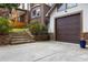 A detached garage featuring stone accents, a brown door, and an inviting stone staircase at 3996 Spalding Ln, Atlanta, GA 30350