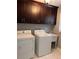 Well-equipped laundry room featuring modern washer, dryer, built in sink and cabinetry for convenient chores at 3996 Spalding Ln, Atlanta, GA 30350