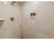 Close-up of a neutral tiled shower with a built-in niche and bronze shower fixtures at 3996 Spalding Ln, Atlanta, GA 30350