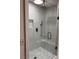 Modern tiled shower features clear glass doors, built-in seat, and rain shower head at 3996 Spalding Ln, Atlanta, GA 30350