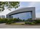 Modern building features expansive glass windows, complemented by manicured landscaping and surrounding trees at 4244 River Green Nw Dr # 111, Atlanta, GA 30327