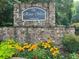 Stone sign for The River West Condominium community with flowers in the foreground at 4244 River Green Nw Dr # 111, Atlanta, GA 30327