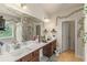 Bathroom featuring a double sink vanity, large mirror, and decorative vine accents at 1749 Charcoal Ives Rd, Lawrenceville, GA 30045