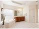 Bright bathroom featuring a soaking tub, tiled floors, and a spacious vanity at 2322 Norbury Se Cv, Smyrna, GA 30080