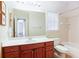 Bright bathroom featuring a cherry vanity with white countertop, a toilet, and a tiled shower/tub combo at 2322 Norbury Se Cv, Smyrna, GA 30080