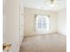 Bright bedroom with a large window, ceiling fan, and neutral-colored walls and carpet at 2322 Norbury Se Cv, Smyrna, GA 30080