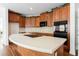 Kitchen featuring large island with cooktop, light countertops, and a suite of black appliances at 2322 Norbury Se Cv, Smyrna, GA 30080