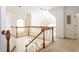 Open landing with wood railings overlooking the staircase below and showcasing natural light from a round window at 2322 Norbury Se Cv, Smyrna, GA 30080
