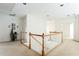 Upper landing area with white walls, wood railings, neutral carpeting, and doorway views at 2322 Norbury Se Cv, Smyrna, GA 30080